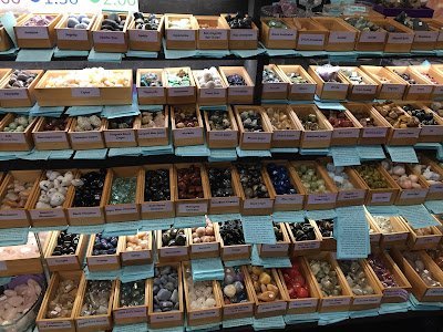 Display with various crystals including jaspers, calcites, quartzes, and aventurines