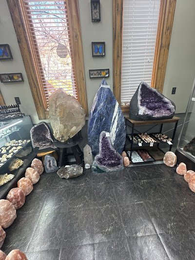 Display of crystal jewelry, tumbled stones, and carved gemstone pieces