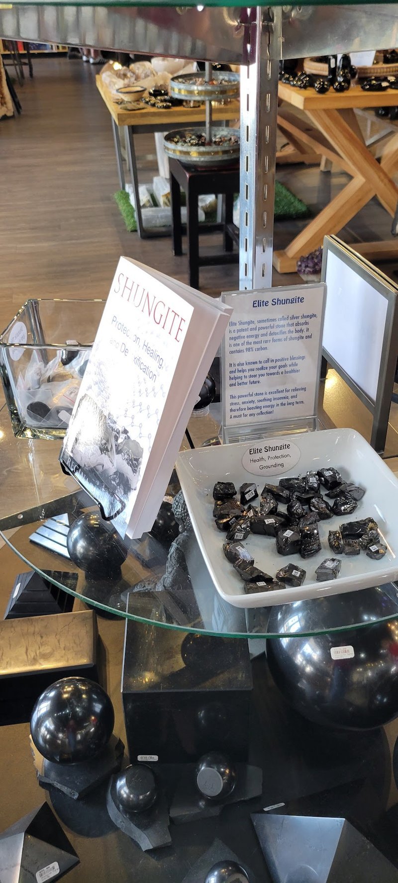 Glass display bins filled with raw amazonite, tumbled stones, and various minerals sorted by type