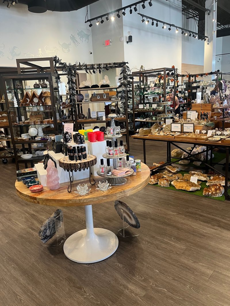Elite shungite display with spheres and raw specimens on glass shelving with informational card