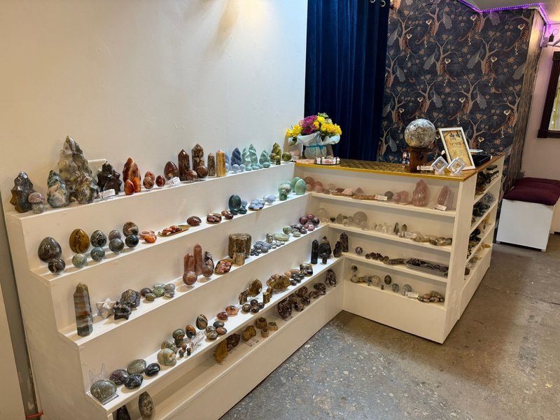 Wooden tray with raw crystal specimens including rose quartz, smoky quartz, fluorite, and black tourmaline