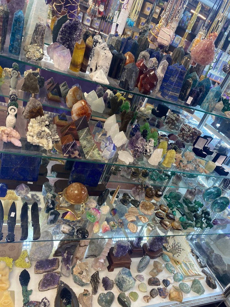 Shelving display featuring amethyst, quartz, and various crystal specimens