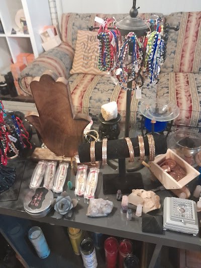 Wooden tiered display featuring purple amethyst clusters, geodes, and spheres with natural lighting