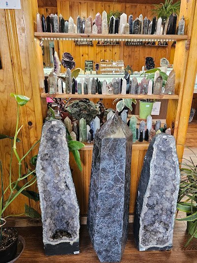 Display of crystal jewelry, tumbled stones, and carved gemstone pieces