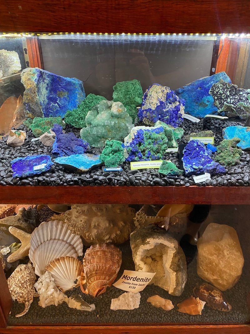 Shelving display featuring amethyst, quartz, and various crystal specimens
