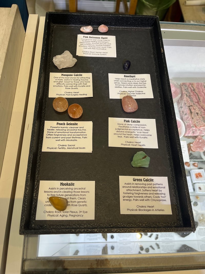 Shelving display featuring amethyst, quartz, and various crystal specimens