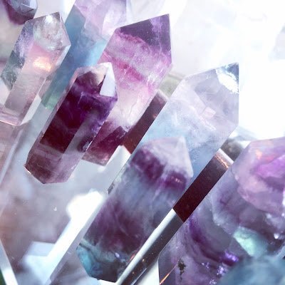 Display of crystal jewelry, tumbled stones, and carved gemstone pieces