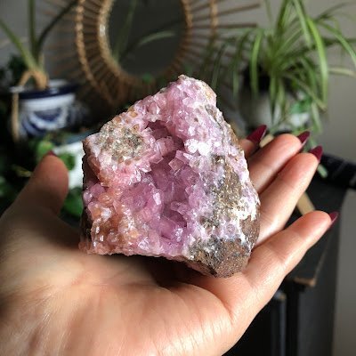 Pink cobaltoan calcite crystal specimen held in hand