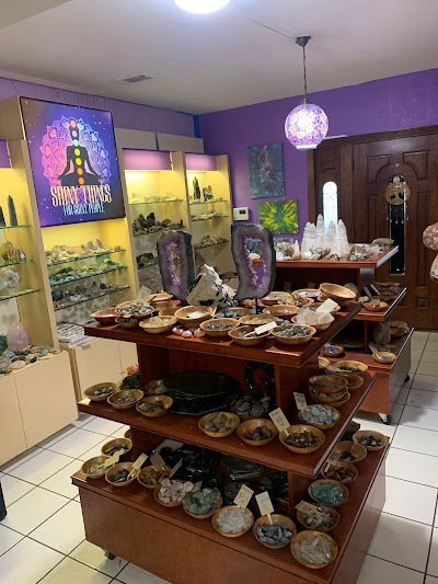 Interior display with wooden tables showcasing crystals, geodes, and amethyst specimens