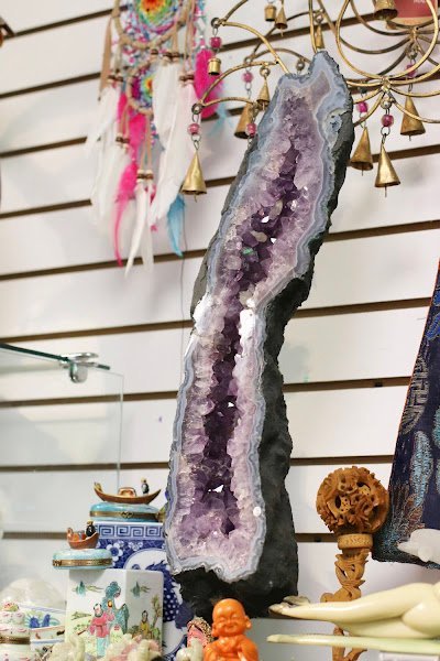 Shelving display featuring amethyst, quartz, and various crystal specimens