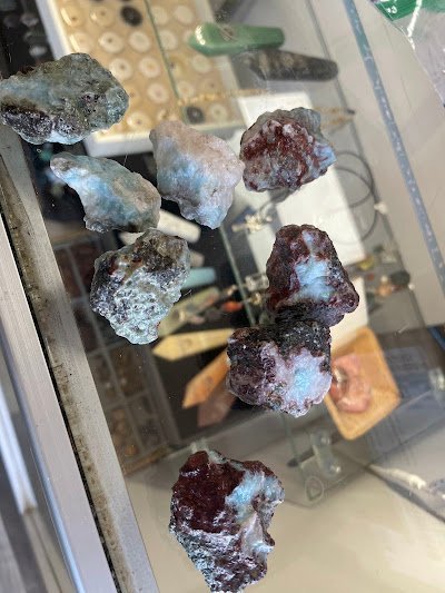 Raw garnet and ruby crystal specimens in glass display case