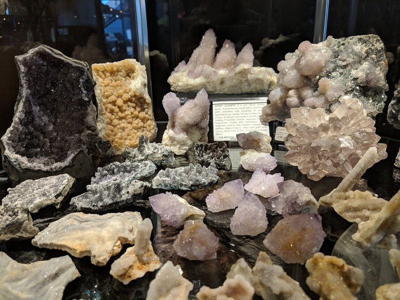 Variety of gemstones, crystal carvings, and polished mineral specimens