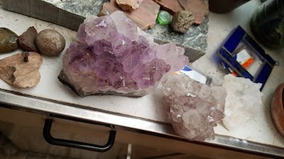 Shelving display featuring amethyst, quartz, and various crystal specimens