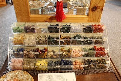 Shelving display featuring amethyst, quartz, and various crystal specimens