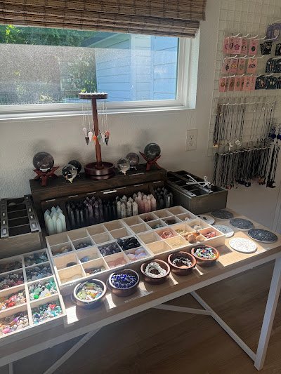 White display table with organized crystal specimens in compartmented trays and decorative bowls