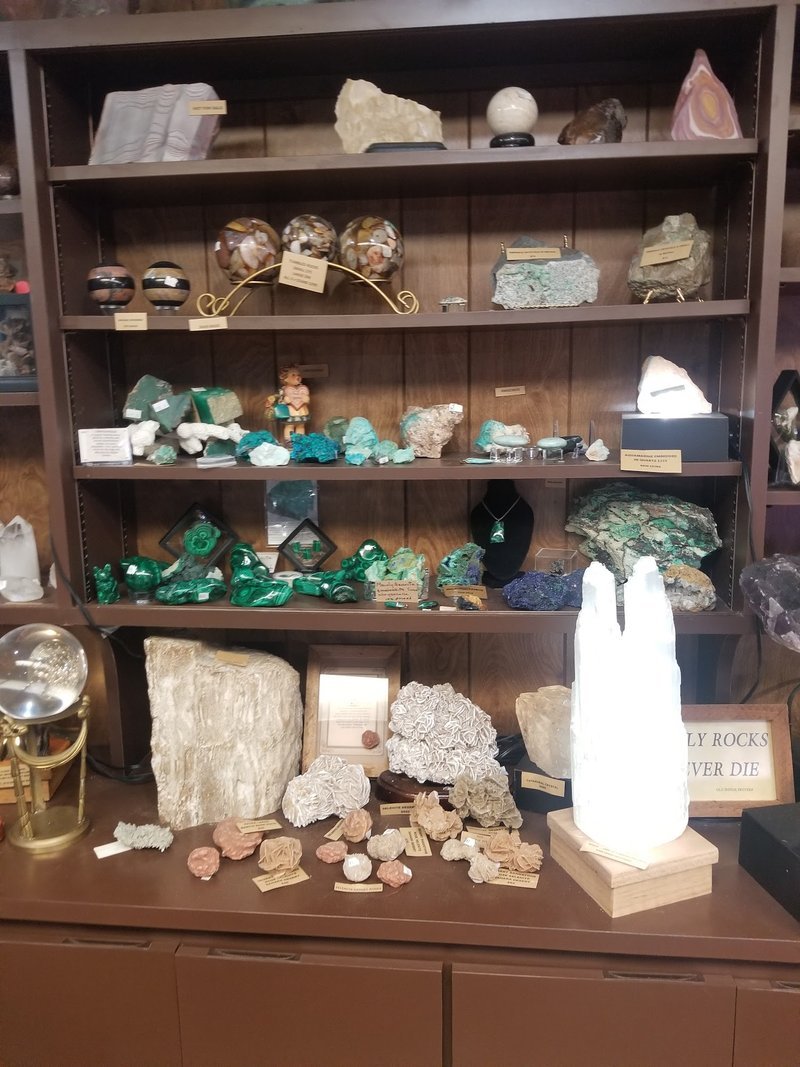 Shelving display featuring amethyst, quartz, and various crystal specimens
